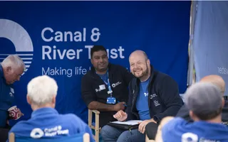 Group of colleagues in branded clothing sitting in chairs having a discussion