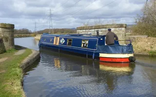 Boat drives through a narrower part of the canal at Brock Aqueduct