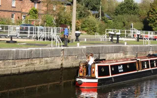 Lady on moored narrowboat talking to volunteer on bank