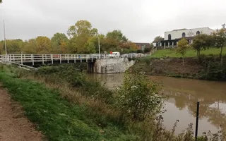 Wide shot of a canal with bridge in the background