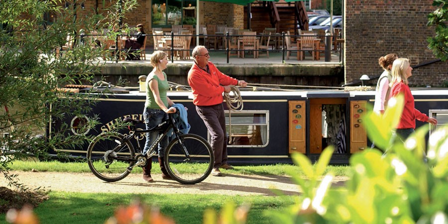 walkers, a cyclist, angler and boater on the Grand Union Canal