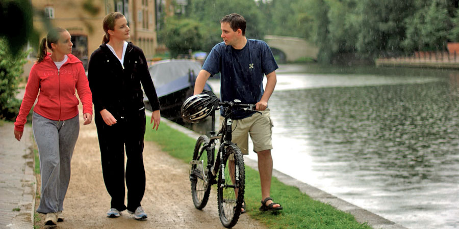 A cyclist talking to two walkers on the towpath