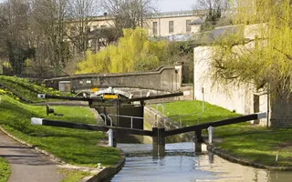 Empty lock surrounded by residential buildings and a bridge in dappled sunlight