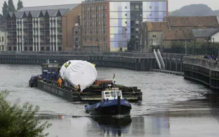 Tug pulling barge with large freight on River Trent