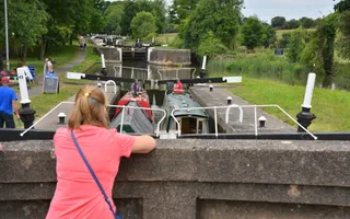 A lady watches two boats passing through Hatton Locks