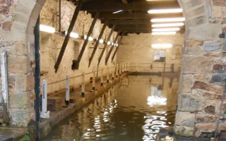 A stone building entryway showing a dry lock lit up by fluorescent lighting
