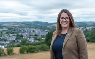 Woman posing for photo with countryside background