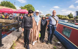 Family walking past moored narrowboats