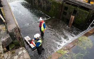 Two men stand inside Winkwell Lock to conduct repairs