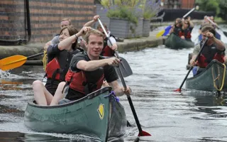 A group of people canoing through the centre of Birmingham