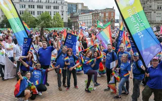 Group of people together posing with rainbow decorations