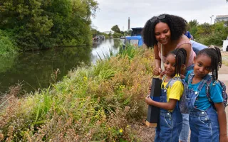 Mother and two daughters dressed for summer standing next to a canal