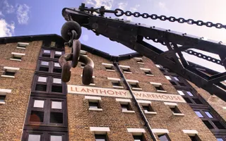 Crane in front of a large brick warehouse