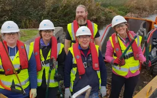 group of people on boat holding tools