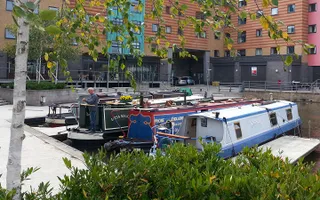 Boats moored in Loughborough Basin surrounded by colourful high-rise buildings