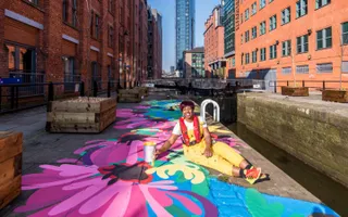 Woman painting mural on towpath floor