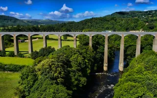 A multi-arched aqueduct crosses the valley floor